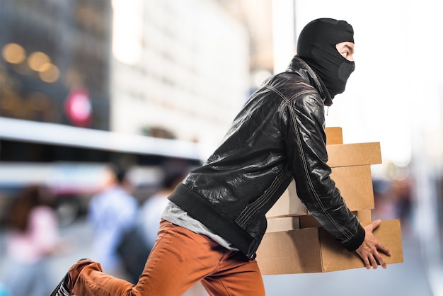 Foto robber celebración de cajas en el fondo desenfocado