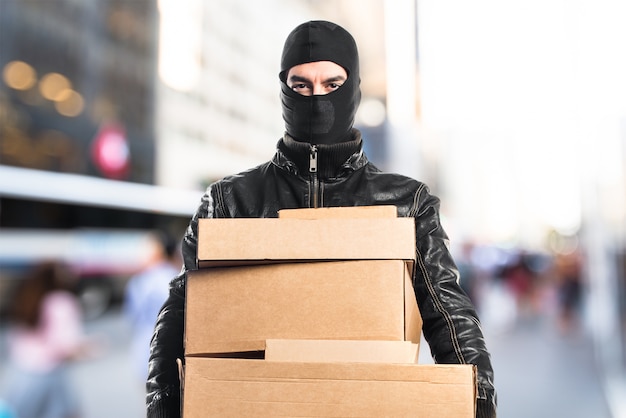 Robber hält Boxen auf unfokussierten Hintergrund