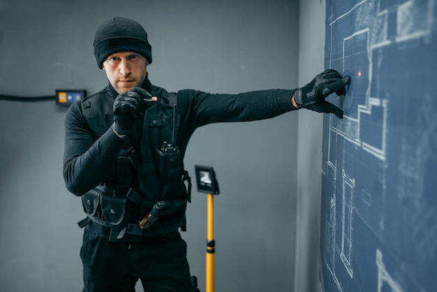 Robo de banco, ladrón masculino en uniforme negro