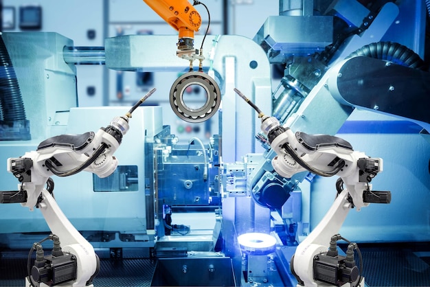 Robô de soldagem industrial e robô de empunhadura trabalhando com peças de metal na fábrica inteligente