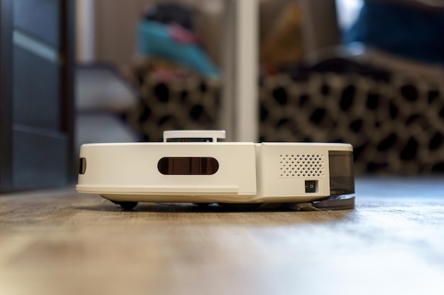 El robot aspirador realiza la limpieza automática del apartamento Hogar inteligente Enfoque selectivo