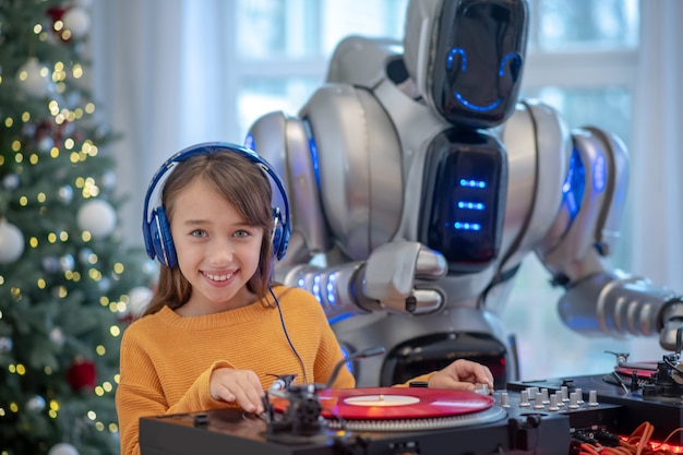 Robot escuchando música de pie junto a la mesa de dj