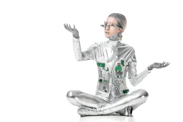robot plateado sentado y tocando algo aislado en el concepto de tecnología del futuro blanco