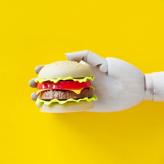 Foto roboterhand, die einen hamburger durchlöchert