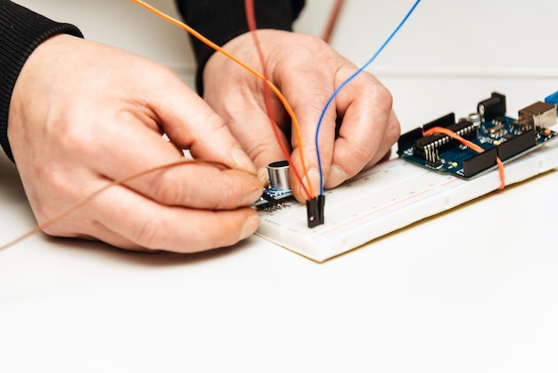 Robótica El hombre hace un robot Tecnologías modernas Desarrollo de sistemas técnicos automatizados Un mecánico está montando un robot Closeup Stem Concept