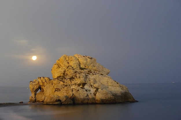 roca en el agua en el mar mediterráneo en la noche