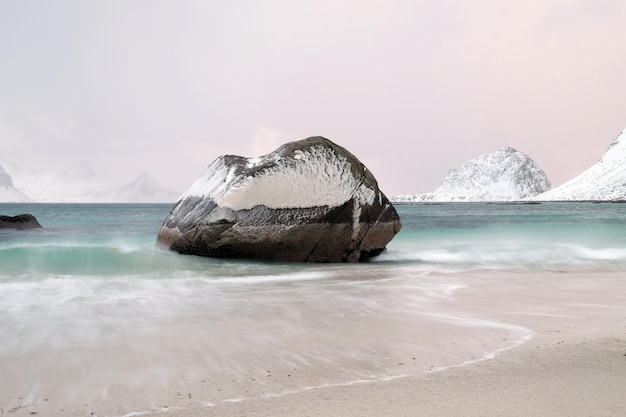 Roca congelada sobre el mar contra el cielo