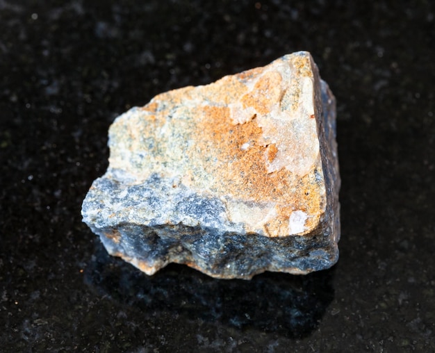 Roca de corindón sin pulir sobre negro