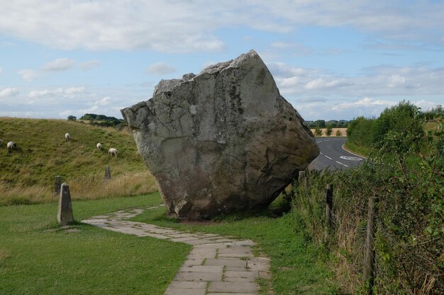 Roca cuadrada gigante en un prado con ovejas en Inglaterra