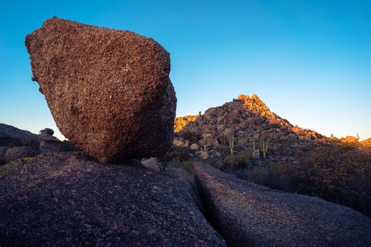 Foto roca equilibrada y montaña cholla al atardecer