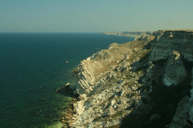 Foto roca junto al mar en un día soleado