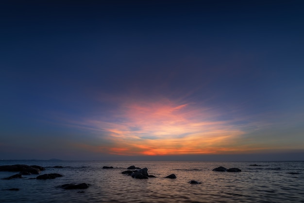 La roca en el mar con el cielo del atardecer