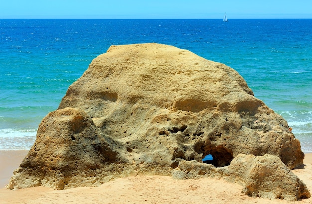 Roca en la playa de arena de verano de Albufeira (Algarve, Portugal).