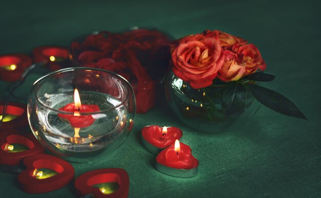 Roca de rosas, velas y tarjetas de regalo para el 14 de febrero, Día de San Valentín, 8 de marzo, Día Internacional de la Mujer, boda, cumpleaños, día de las madres, fondo borroso.