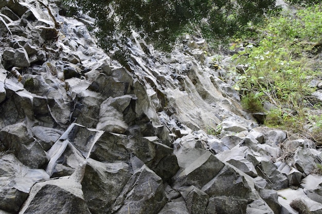 Roca tallada junto al río Pailon del Diablo Mountain y cascada en los Andes Banos