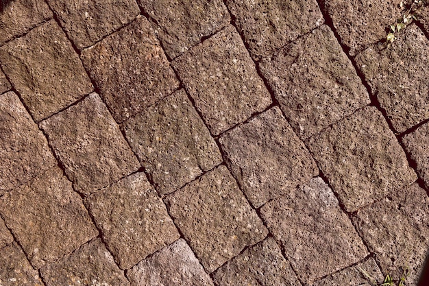 Roca volcánica de basalto pavimentando el bloque de piedra pómez de la carretera para construir la antigua muralla de la ciudad parte de la antigua carretera de la ciudad