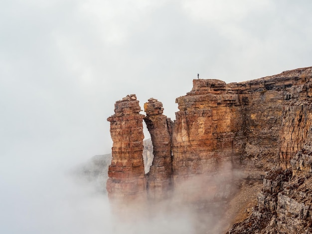 Rocas afiladas en la niebla Montañas en una densa niebla Paisaje místico con hermosas rocas afiladas en nubes bajas