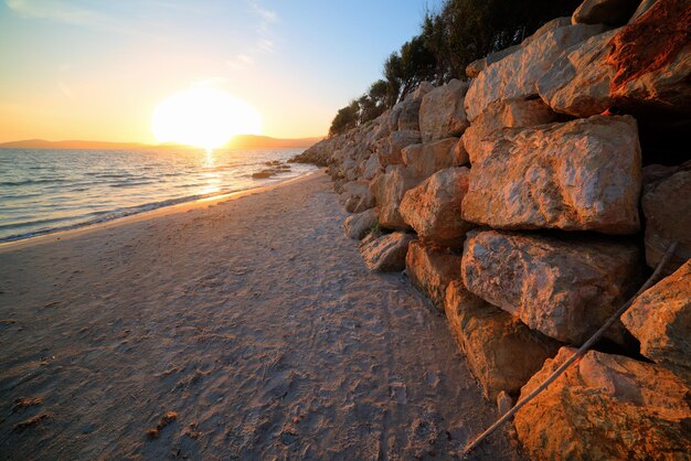 Rocas y arena en la costa de Alghero al atardecer Cerdeña