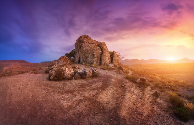 Rocas contra increíble cielo nublado en el desierto al atardecer