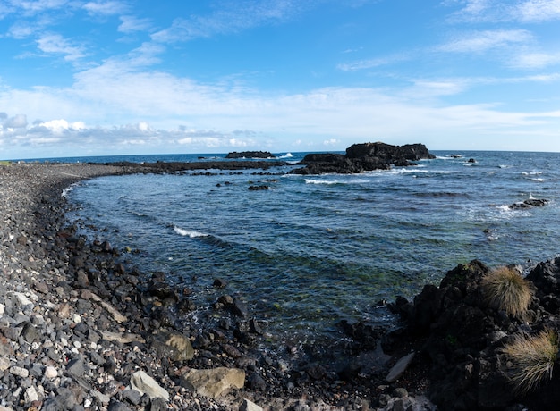 Rocas de la costa en las azores. Olas chapoteando en rocas de basalto