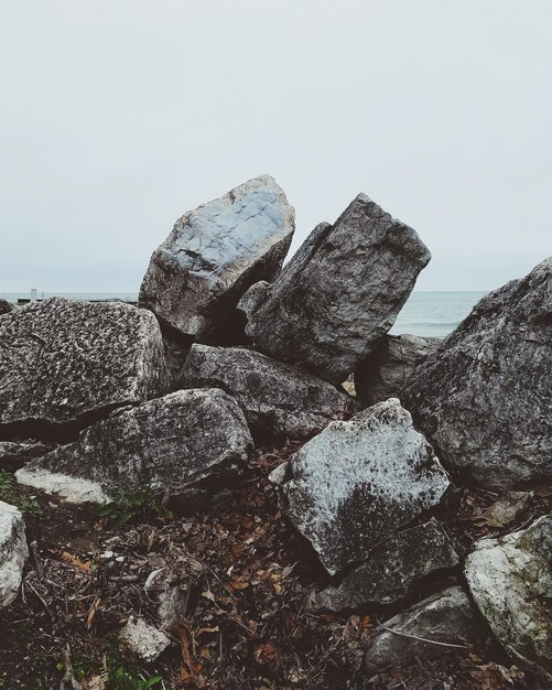 Las rocas por el mar contra el cielo despejado