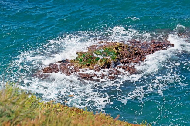 Rocas marrones rodeadas de olas