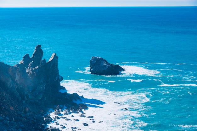 Foto las rocas en la orilla del mar contra el cielo azul