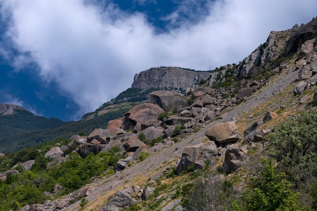 Rocas de paisaje de montaña con enormes rocas colapsadas contra un cielo con nubes