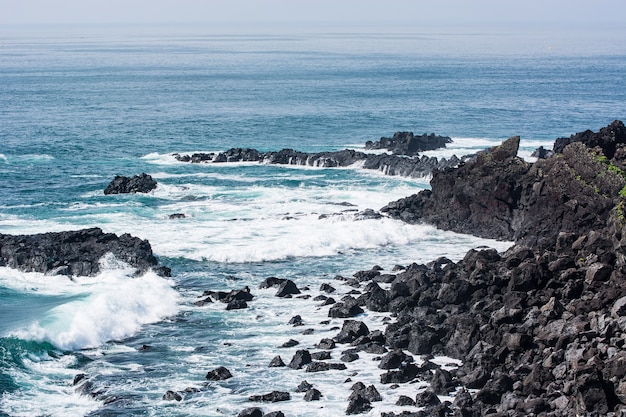 Rocas en la playa con agua de mar clara en Seopjikoji Jeju Island South Korea.