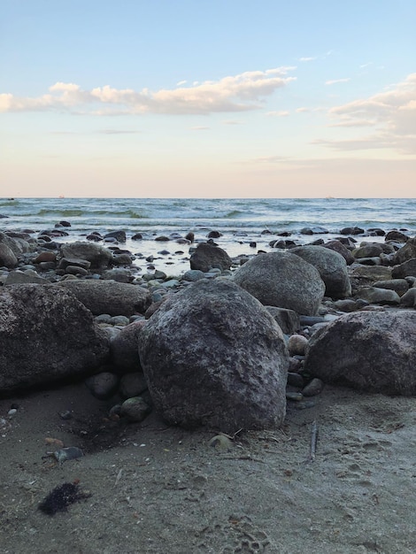 Foto rocas en la playa contra el cielo durante la puesta de sol