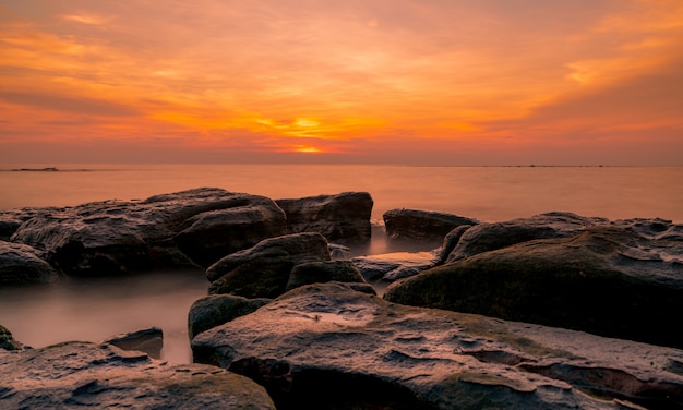 Rocas en la playa de piedra al atardecer. Hermoso cielo al atardecer playa. Mar tropical al anochecer