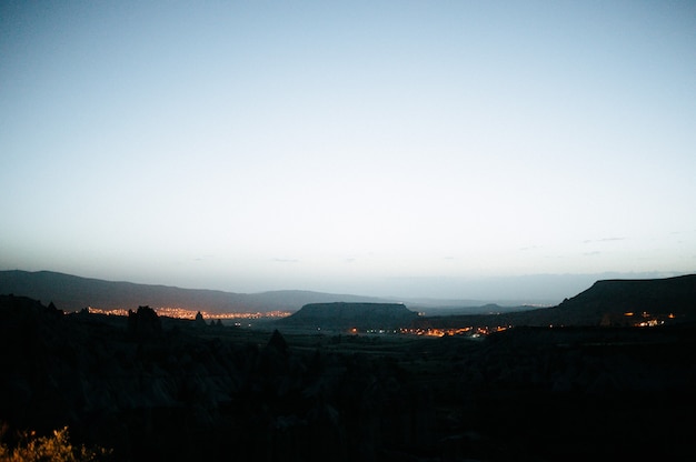 Rocas que parecen setas iluminadas dramáticamente por una puesta de sol en Capadocia, Turquía