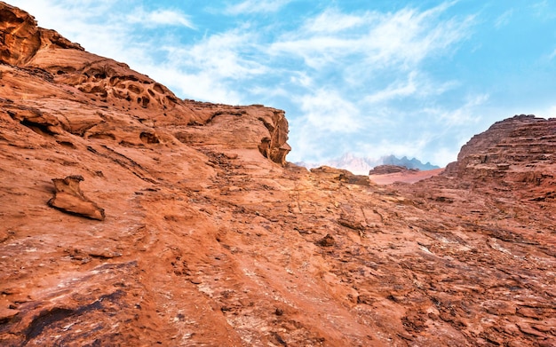 Rocas rojas y polvo en Wadi Rum, desierto de Jordania - paisaje que parece un planeta diferente o un escenario de película de ciencia ficción