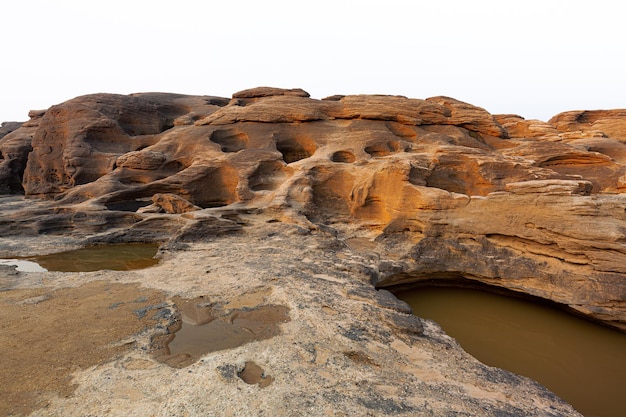 rocas sobre un fondo blanco La roca del acantilado se encuentra parte de la roca de la montaña aislada en un blanco