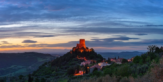 Rocca d'Orcia uma vila medieval e fortaleza na Toscana Itália Vista única ao entardecer a torre de pedra empoleirada no penhasco rochoso contra o céu dramático