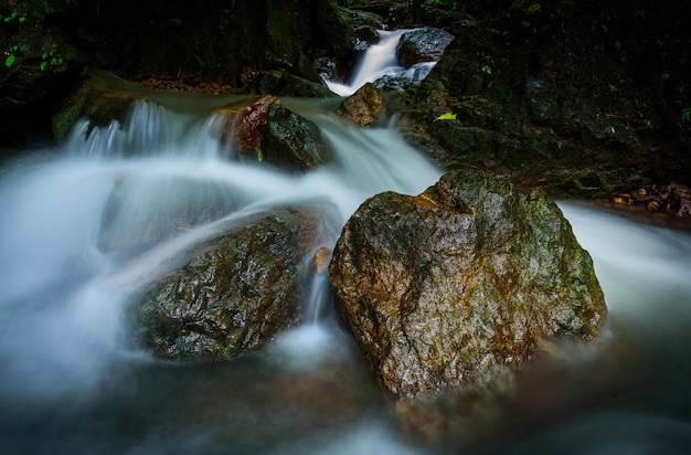 Rocha grande na floresta na cachoeira de Nangrong, província de Nakhon Nayok, Tailândia com exposição longa na manhã.