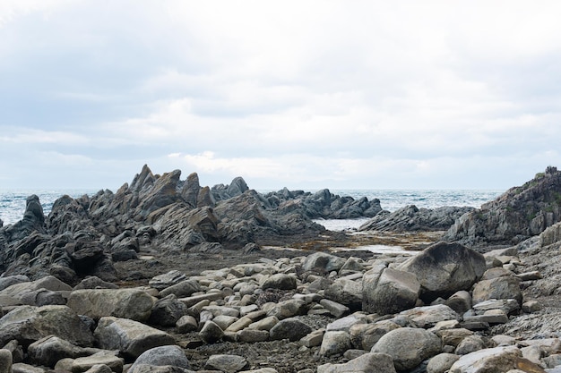 Rochas de basalto afiadas na costa marítima do Cabo Stolbchaty na ilha de Kunashir