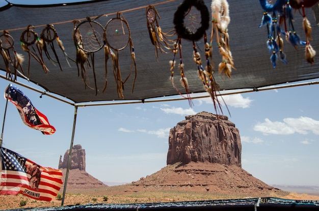 Foto rochas do vale do monumento vistas através de um stand de mercado vendendo bandeiras indianas e caçadores de sonhos