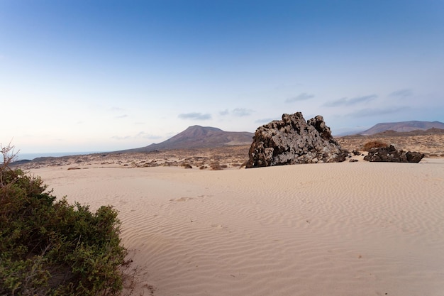 rochas e dunas ao nascer do sol no parque natural de Corralejo, Fuerteventura