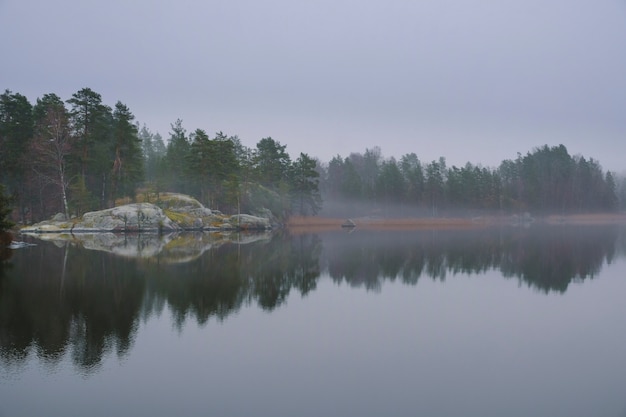 Rochas e floresta no nevoeiro nas margens do lago ladoga no parque nacional ladoga skerries