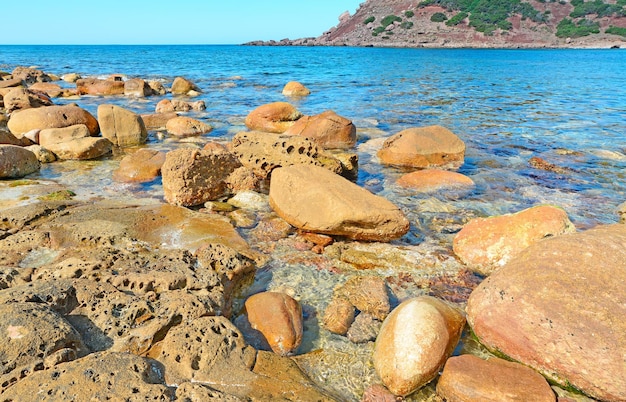 Rochas marrons na praia de Porticciolo na Sardenha