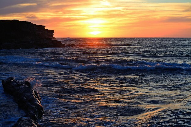 Rochas na água em Porto Ferro ao pôr do sol na Sardenha