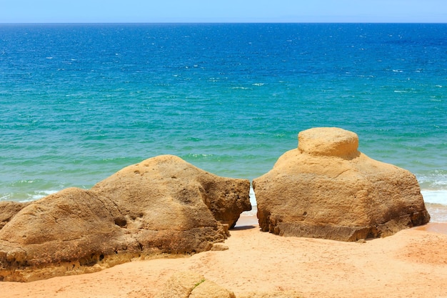 Rochas na praia de areia de albufeira de verão (algarve, portugal).