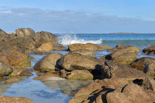 Rochas no fundo do mar e ondas em uma praia da Bretanha, França