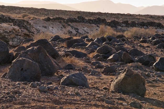 Rochas vulcânicas espalhadas pelo terreno árido perto de Puerto Lajas em Fuerteventura