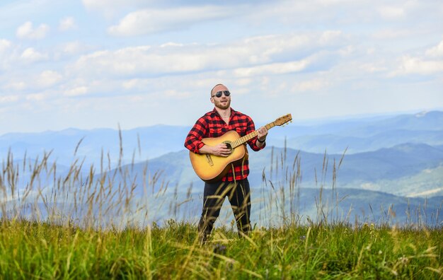 Rock with you sexy man con guitarra en camisa a cuadros hipster moda occidental camping y senderismo