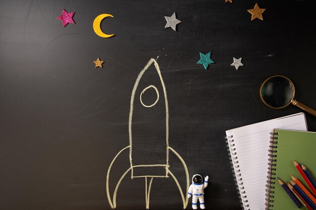 Foto rocket desenho de giz no quadro e astronauta de brinquedo