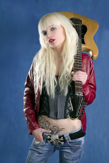 Foto rockstar-blauhintergrund des jungen mädchens der blonden reizvollen jungen frau der elektrischen gitarre