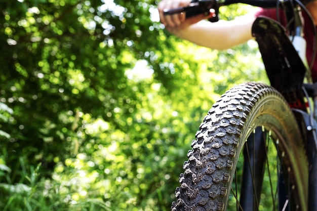 Roda de bicicleta fechada no campo de grama verde de verão Espaço para texto