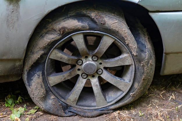 Roda de carro velha e suja desinflada